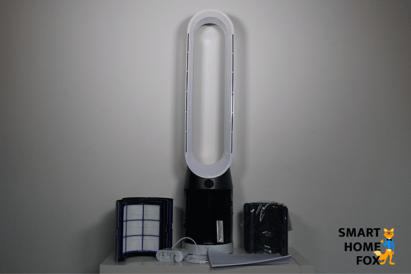 Der Dyson Pure Cool TP04 Luftreiniger , HEPA-FIlter , Aktivkohlefilter, Fernbedienung und Handbuch liegen auf einem weißen Regal